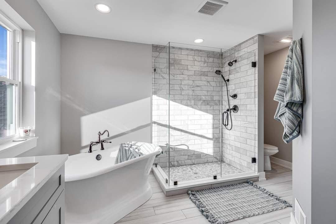 Finished bathroom with a freestanding tub and a marble tiled glass shower, plumbed by TAS Plumbing