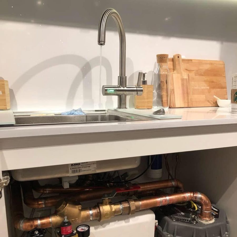 Kitchen sink with a filtered tap and new copper pipework in the cabinet below