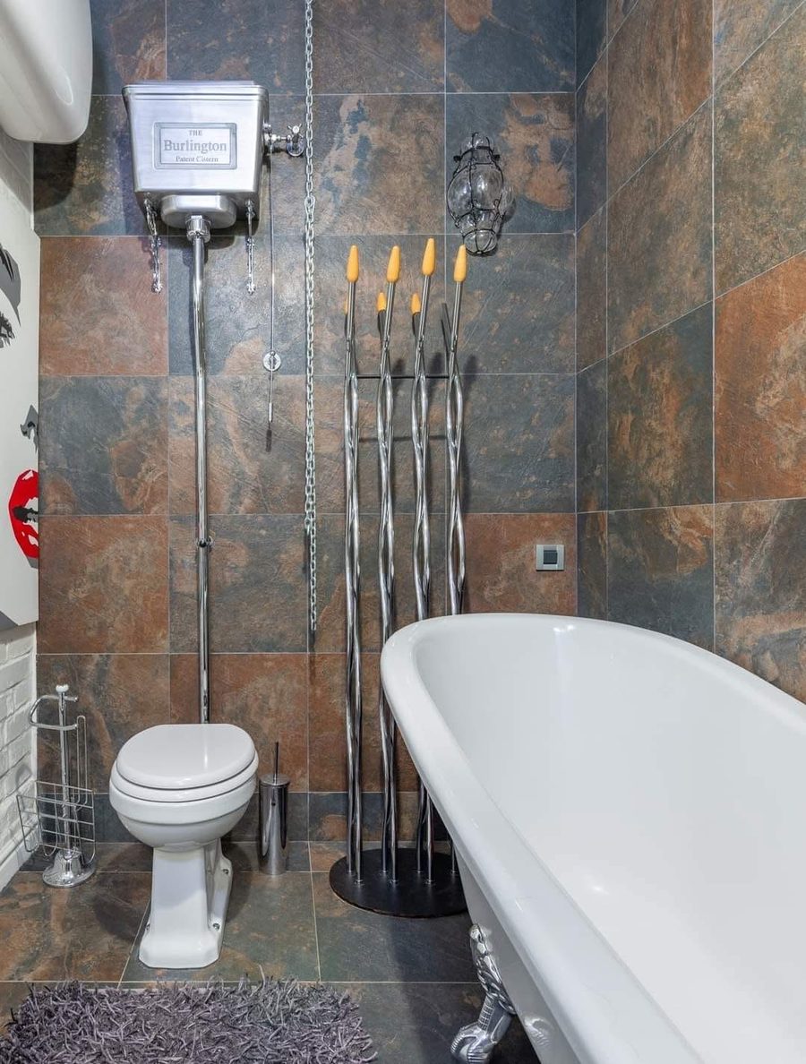 Slate tiled bathroom with a clawfoot tub and a high level cistern toilet