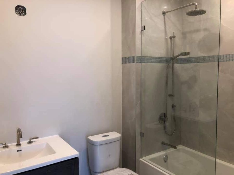 Tub and shower with a glass screen beside a new vanity