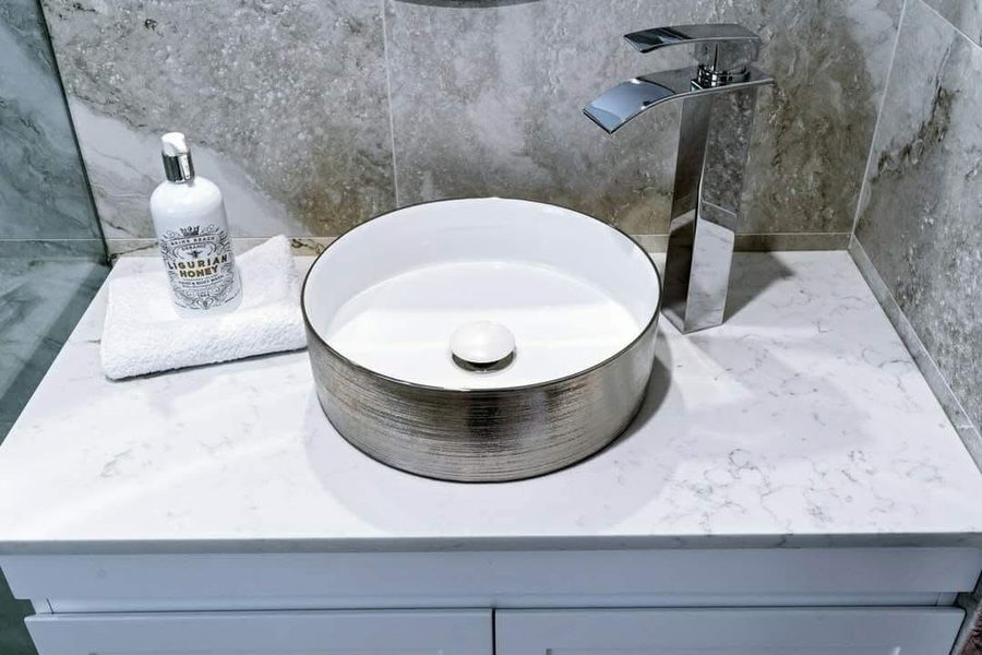 Vessel sink and tall chrome mixer on a quartz vanity top